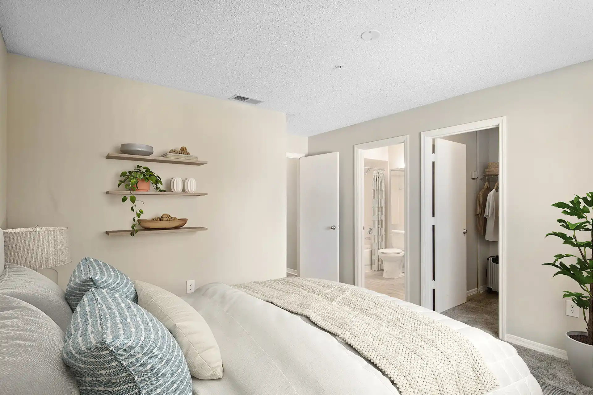 bedroom with three-tiered shelving and walk-in closet