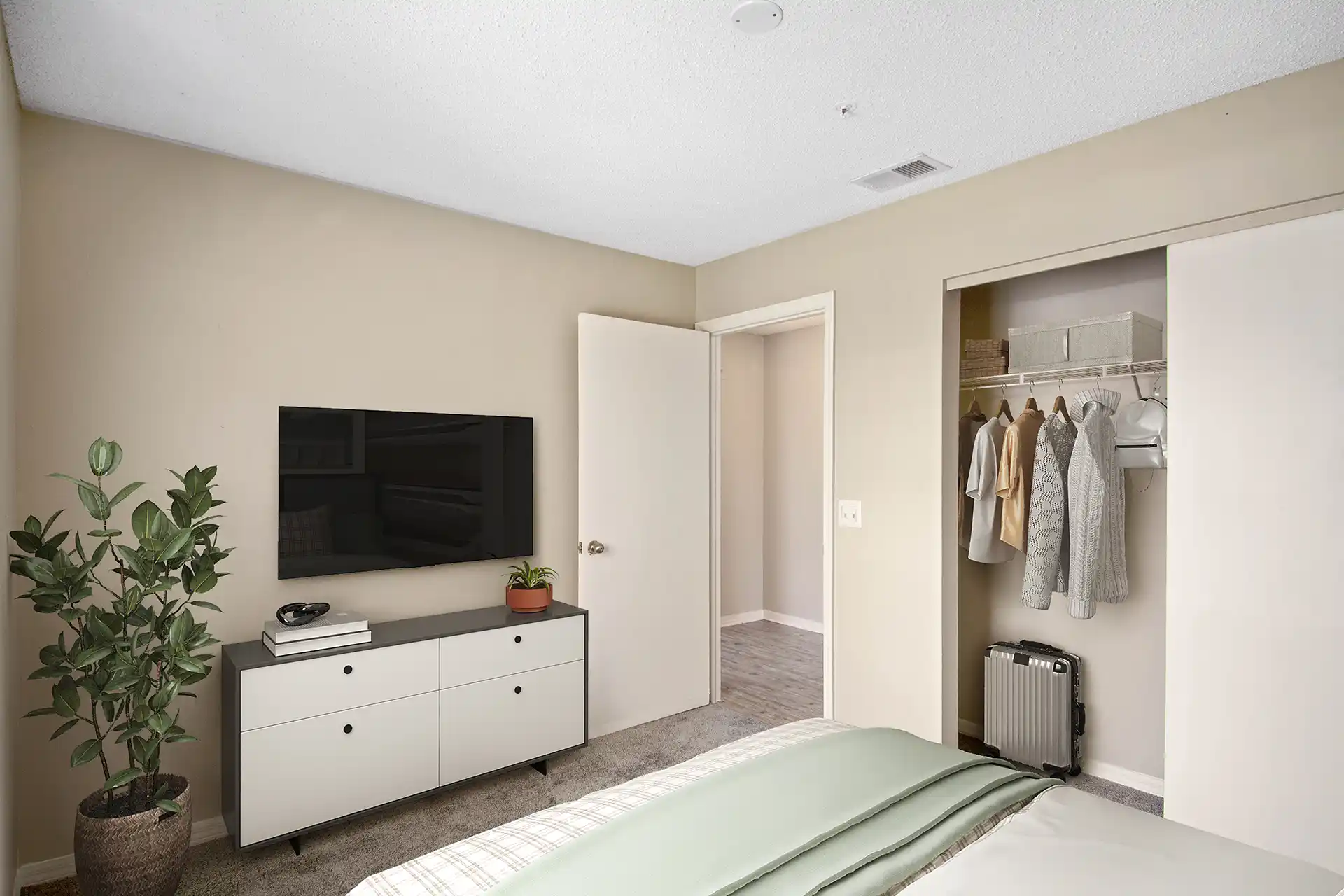 bedroom with closet, carpet and wall-mounted TV
