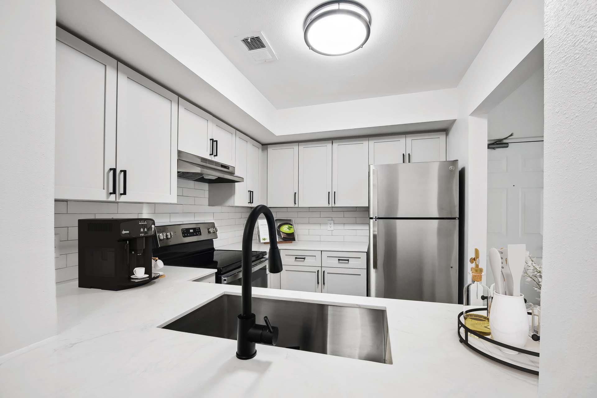 kitchen with white cabinets, white countertops and black hardware