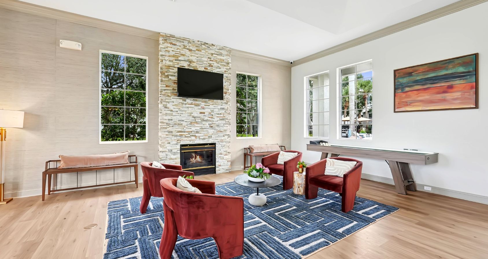 Clubhouse with chic red chairs, modern decor, and stylish lighting, perfect for relaxation and entertaining.