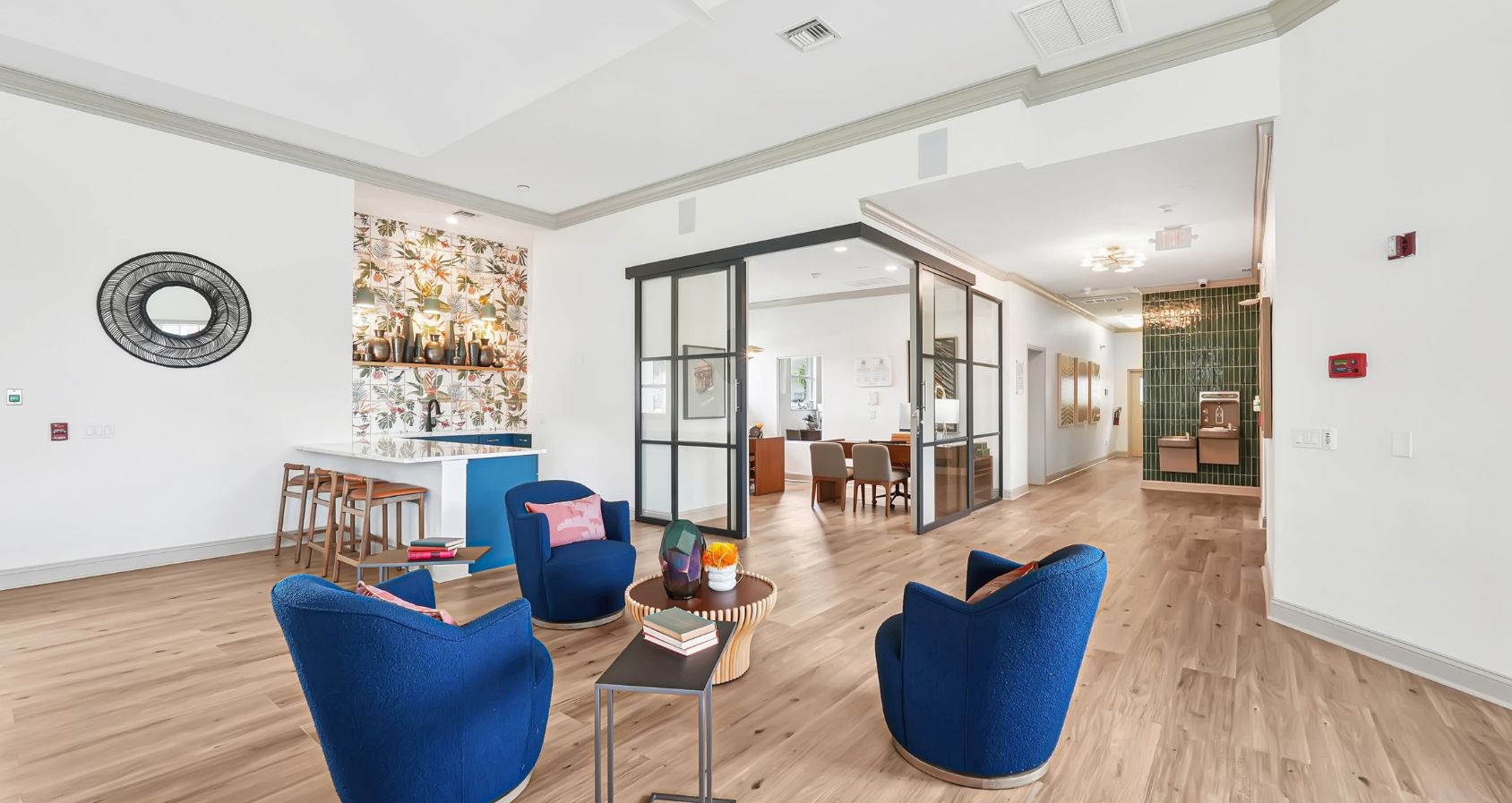 Clubhouse featuring vibrant blue chairs, wooden flooring, and a stylish bar area with floral accents.