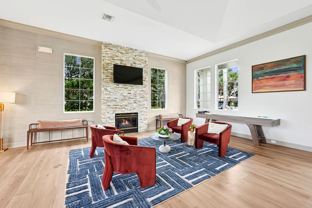 Clubhouse with chic red chairs, modern decor, and stylish lighting, perfect for relaxation and entertaining.
